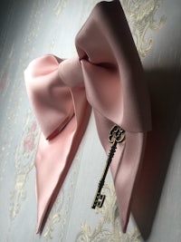 a pink bow with a key on it
