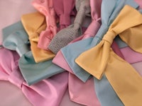 a bunch of pastel colored bow ties laying on top of each other