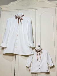 a white shirt with a bow on it and a little girl's shirt