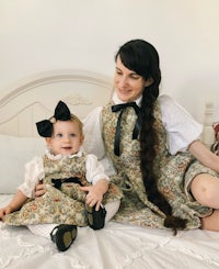 a woman and a baby sitting on a bed